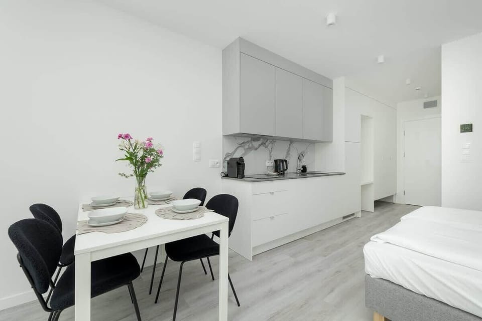 Dining area with flowers and kitchen view
Elegant setting with fresh decor and seamless access to the kitchenette.
