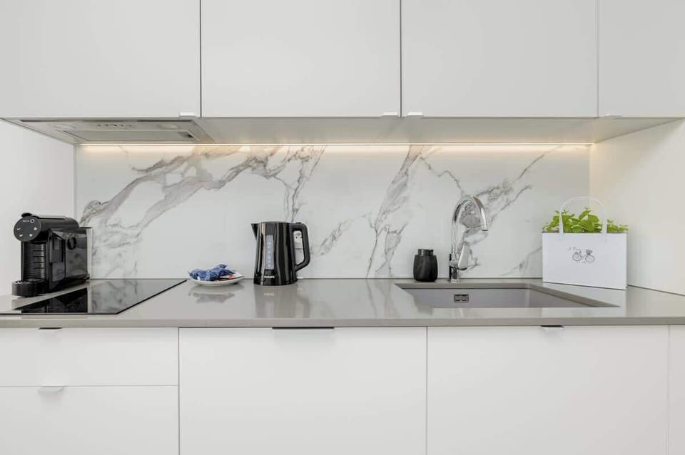 Fully equipped kitchen with marble backsplash
Sleek design, complete with kettle, induction hob, and ambient lighting.