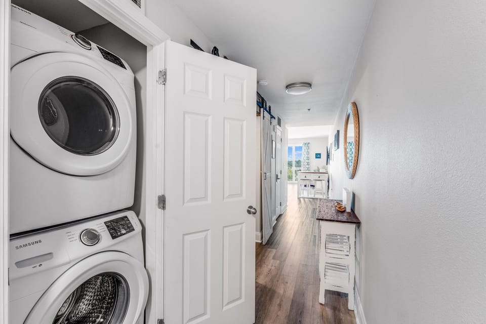 hallway with stacked washer and dryer and natural light from the dining area