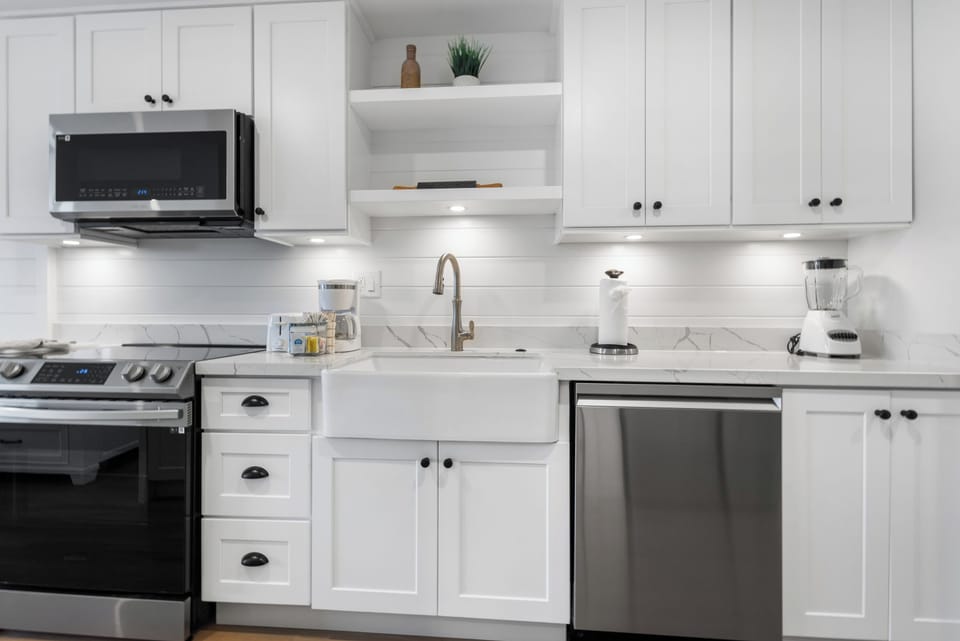 Step into your bright, fully-equipped kitchen with sleek white cabinetry, marble-style counters, and stainless steel appliances. Prepare your favorite meals with ease, surrounded by modern touches and thoughtful storage—your home away from home awaits.