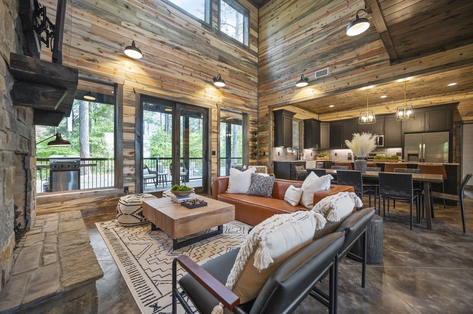 Double height ceiling living room with 65" Smart TV. Dining area and kitchen.
