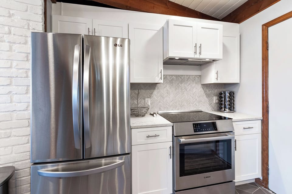 Kitchen with stainless appliances, dishwasher, Keurig and drip-style coffee pot, and access to the garage.