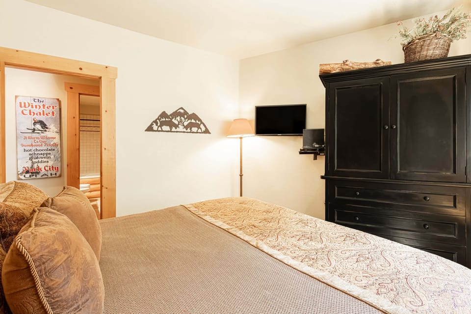 Bedroom 2 with a king bed, TV with cable, and access to full shared bathroom