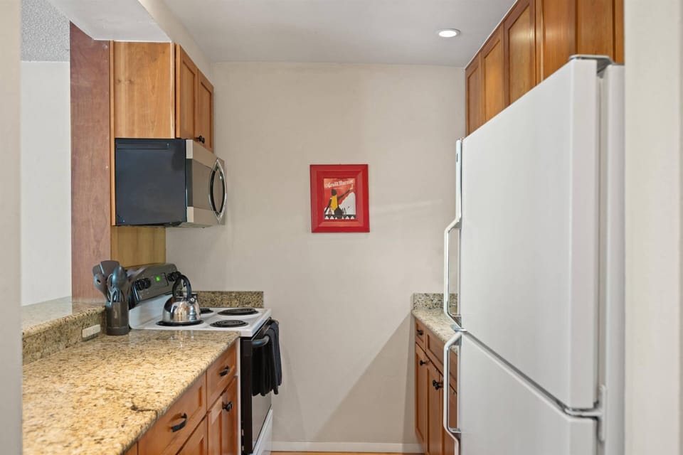 The kitchen offers a stove, microwave, full-size fridge, dishwasher, toaster oven and coffee maker.