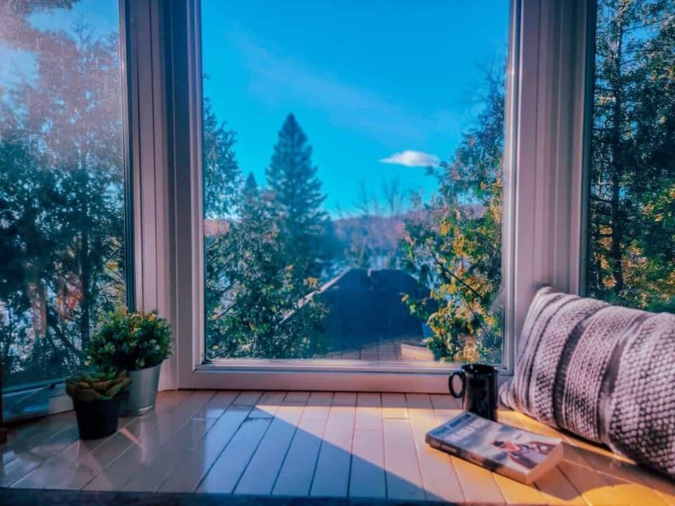 Beautiful window view showcasing lush trees and majestic mountains, bringing nature’s serenity indoors.Beautiful window view showcasing lush trees and majestic mountains, bringing nature’s serenity indoors.