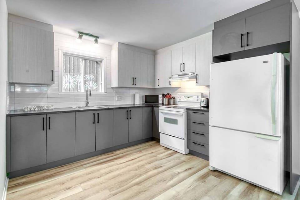 Spacious kitchen with a clean white and gray color scheme, combining modern design with plenty of room to cook and gather.