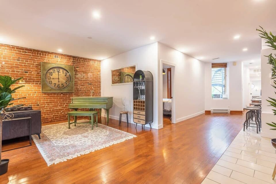 Clean white hallway with vinyl wood flooring leading from the entertainment area—sleek and inviting.