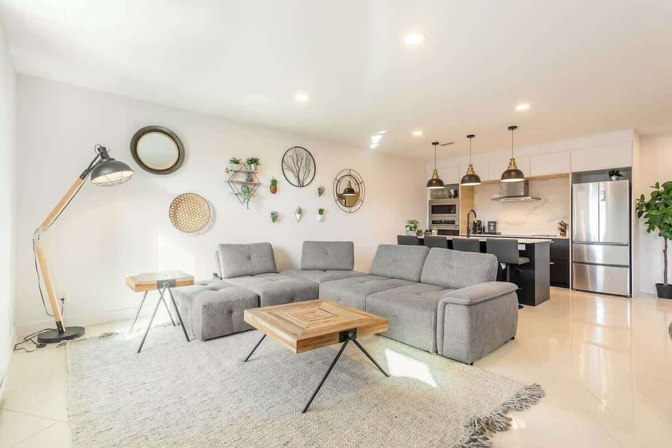 Spacious living area featuring a comfy grey couch and a wooden table—perfect for relaxing or entertaining.Spacious living area featuring a comfy grey couch and a wooden table—perfect for relaxing or entertaining.