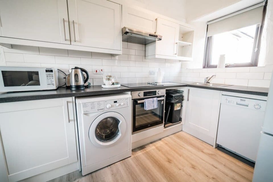 Fully equipped kitchen featuring an oven, induction hob, and washing machine to make your stay feel exactly like home.