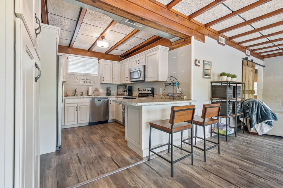Modern kitchen with a bar seating area, high ceilings, and a seamless flow to the living and dining spaces.