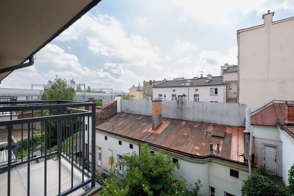Another balcony view overlooking rooftops and nearby buildings. It’s a serene outdoor space for relaxing in the city.