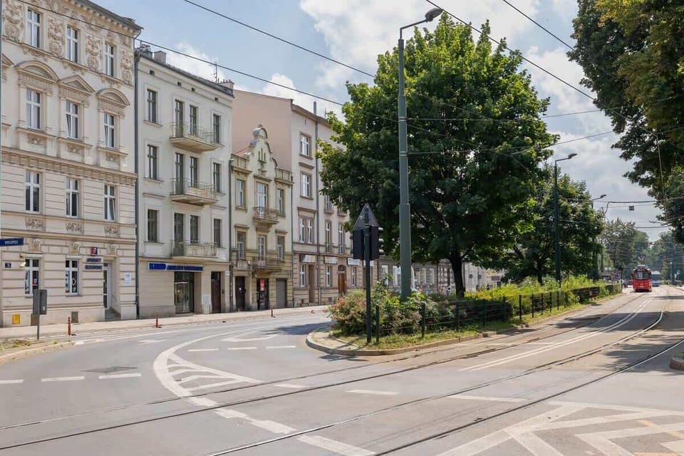 A street corner with classic European architecture and leafy trees. The area looks peaceful and walkable.