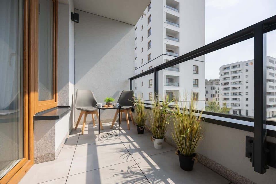 Balcony View – Balcony overlooking the cityscape with seating and plants – a relaxing place to unwind.