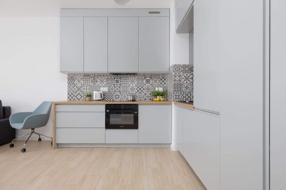 Kitchenette with Kettle – Compact, fully equipped kitchen area with modern backsplash and a kettle for convenience.