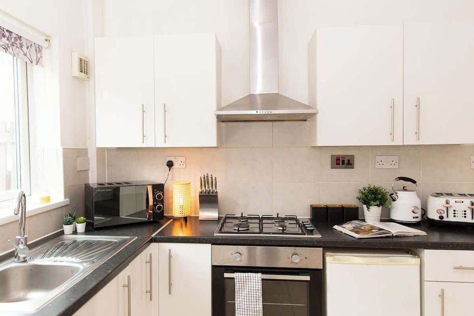 "A small yet sleek and minimalist kitchen, designed for both efficiency and style—perfect for preparing meals in a modern, clutter-free space."