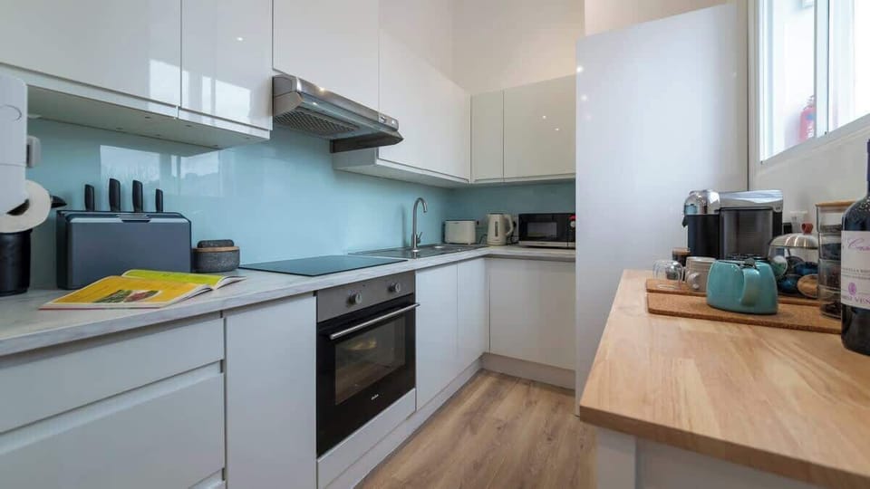 Bright and spotless — a clean kitchen paired with a charming coffee nook, perfect for morning brews and effortless meal prep.