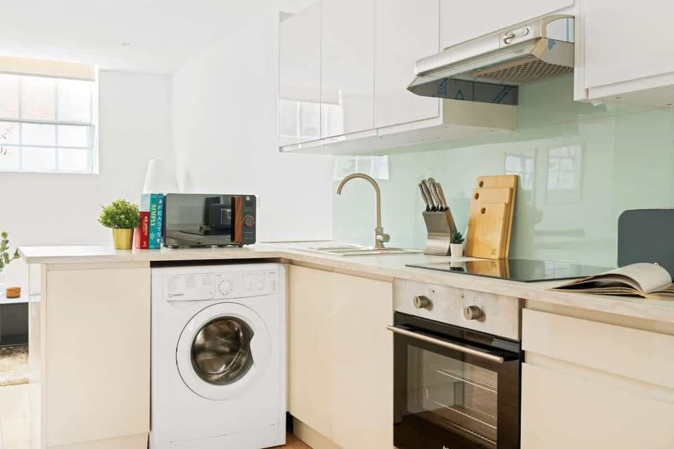 Minimalist and spotless — a clean kitchen area with sleek essentials and a convenient washing machine for a fuss-free stay.