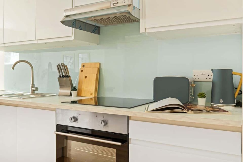 Minimalist and spotless — a clean kitchen area with sleek essentials and a convenient washing machine for a fuss-free stay.