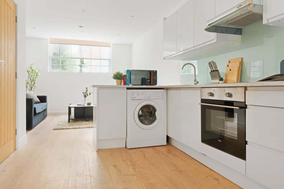 Minimalist and spotless — a clean kitchen area with sleek essentials and a convenient washing machine for a fuss-free stay.