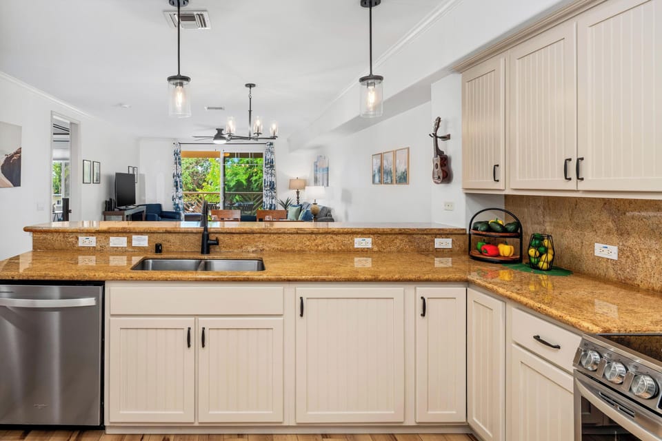 Full kitchen with breakfast bar, granite counters, and stainless steel appliances