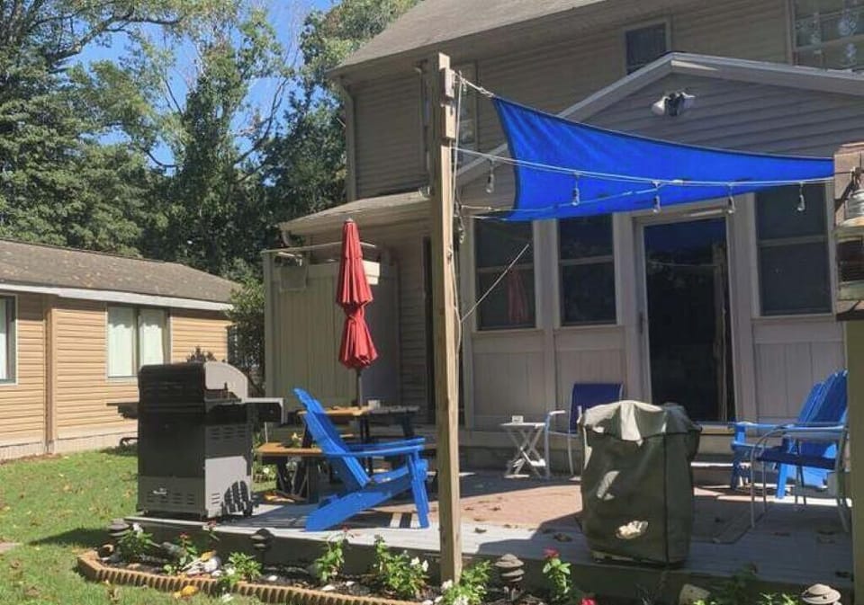 Backyard patio with grill, firepit, and picnic table with umbrella