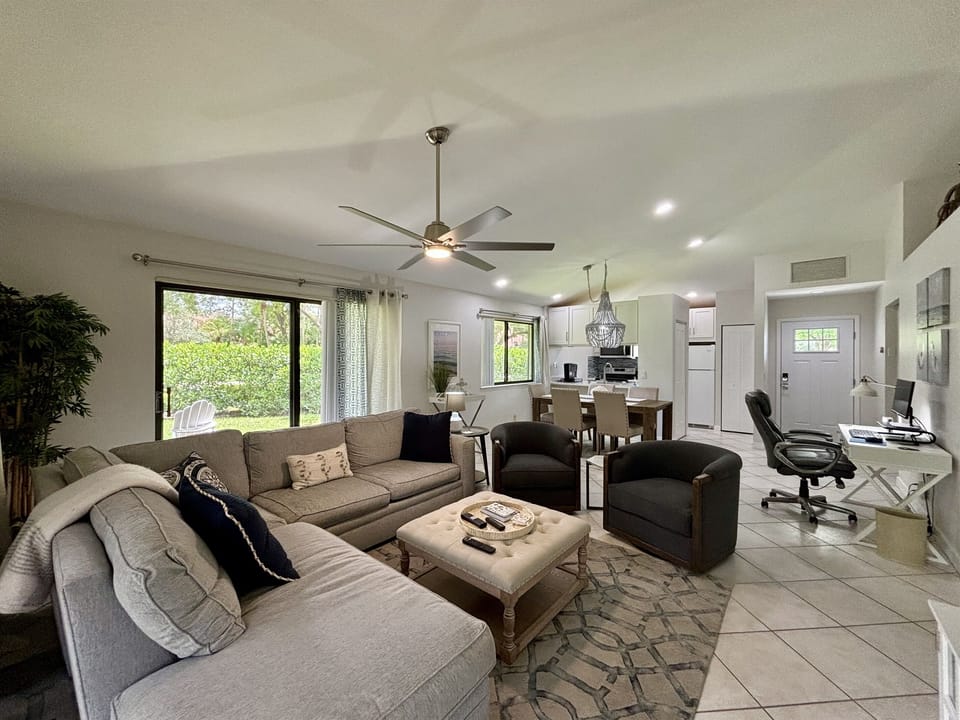 Our large, open living room has seating for six in front of the TV. Two large sliding glass doors let in plenty of light and views of the surrounding, peaceful landscaping.