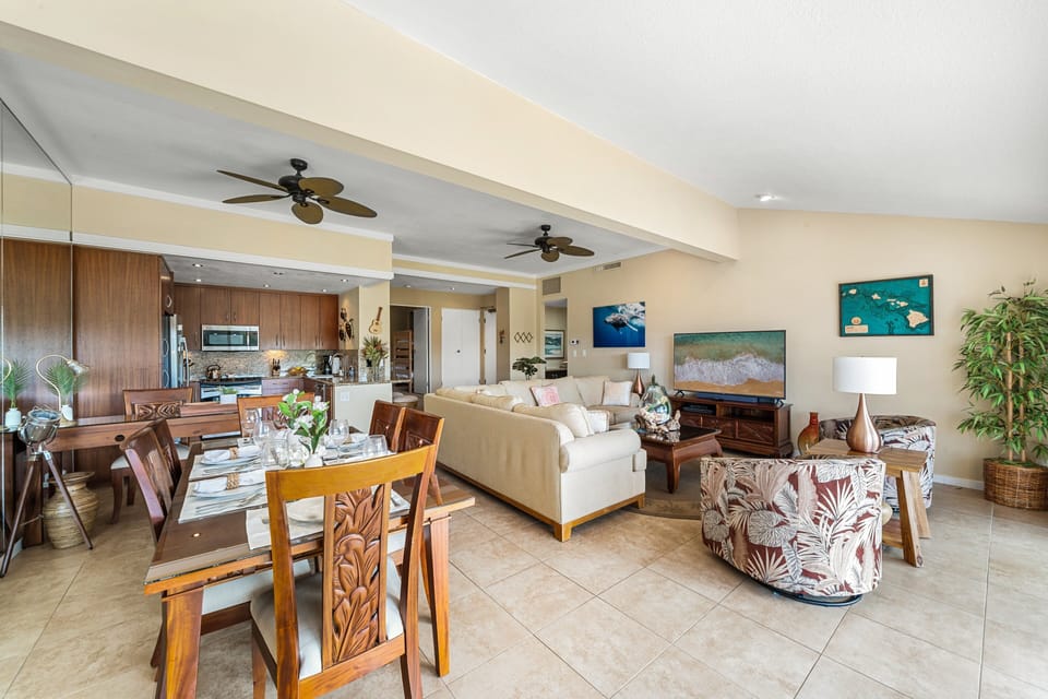 The open-concept design seamlessly connects the living and dining areas with tropical decor and modern amenities.