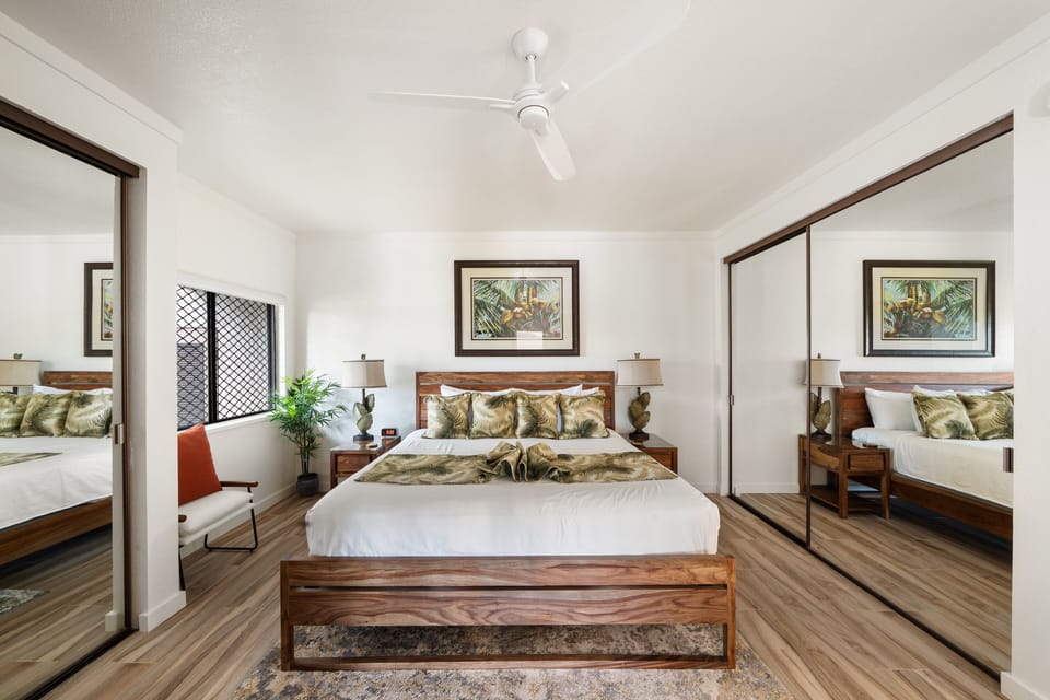 Experience ultimate comfort in this elegantly designed bedroom with mirrored closets, tropical decor, and cozy ambiance, ideal for a restful stay.