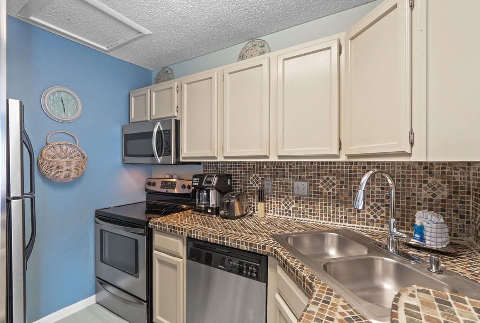 Cook your favorite meals in this fully-equipped kitchen with modern appliances and charming mosaic backsplash.
