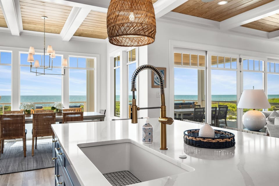 Your stunning kitchen island overlooks breathtaking ocean views through floor-to-ceiling windows.