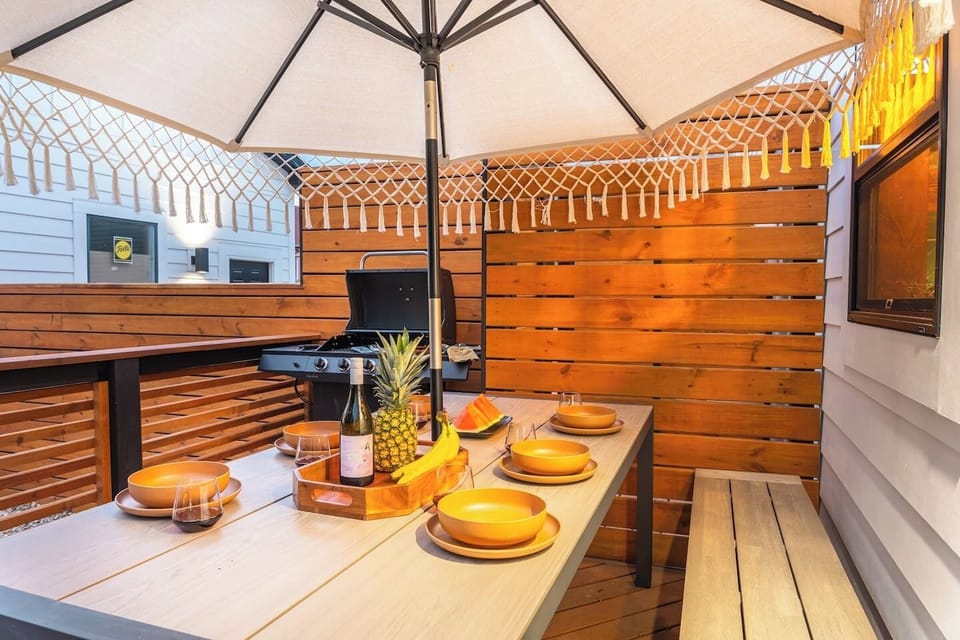 Back terrace featuring outdoor dining table, propane grill, and an oversized umbrella. Essential grilling cookware and outdoor dinnerware are in the kitchen cabinets!