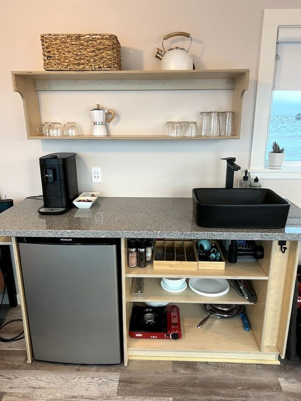 Small kitchen with refrigerator/freezer combo, and one-burner stove and air fryer toaster oven for cooking.