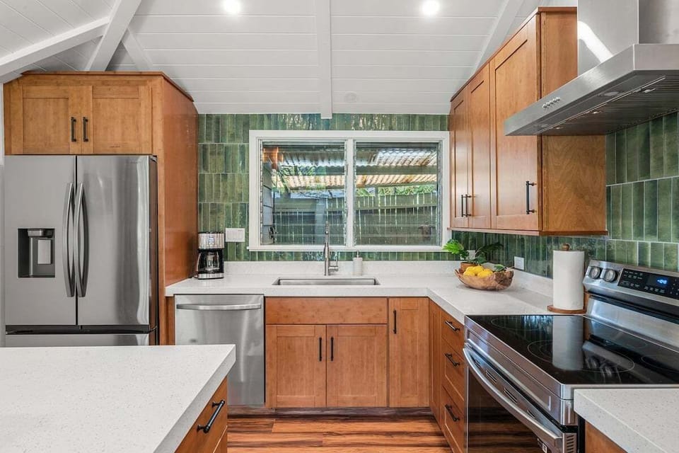 Sleek stainless steel appliances and green tile backsplash add style