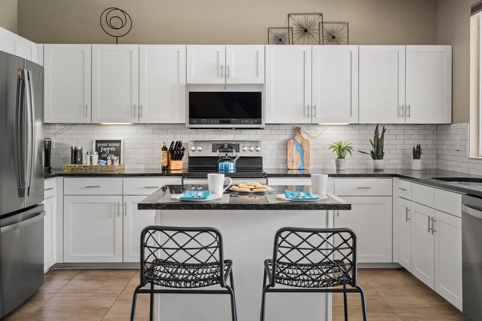 Featuring high-end stainless appliances and a central counter with seating