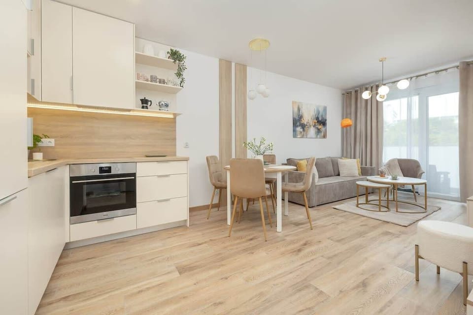 Lounge area with comfortable sofa, Smart TV, access to balcony and kitchenette.