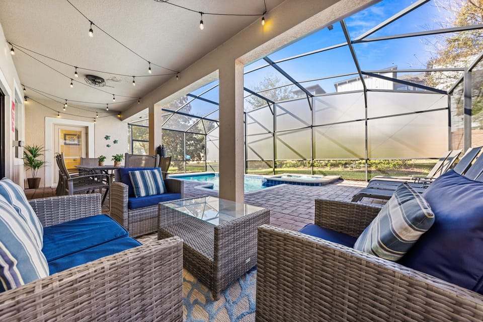 Cozy lounging space under a covered patio, ideal for relaxation and socializing - Stylish outdoor furniture by the private pool with comfortable cushions for added comfort - Overlooks the pool and backyard, providing a tranquil retreat