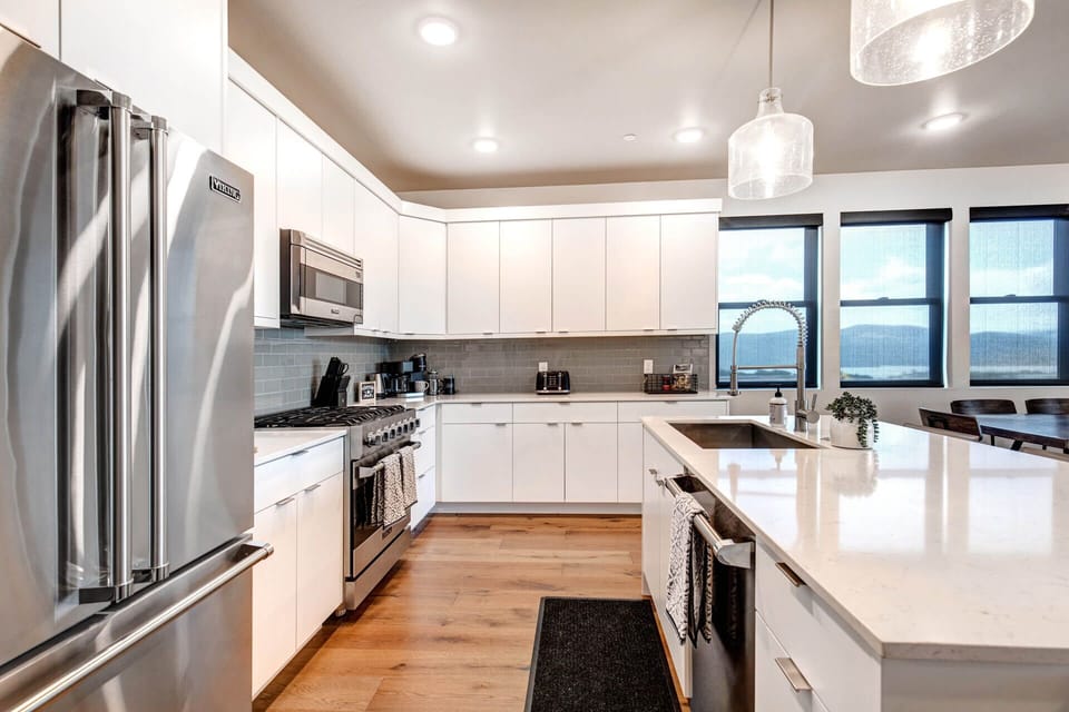 Bright, modern kitchen with stainless steel appliances and stunning water views. Cook your favorite meals while soaking in the serene scenery through expansive windows.