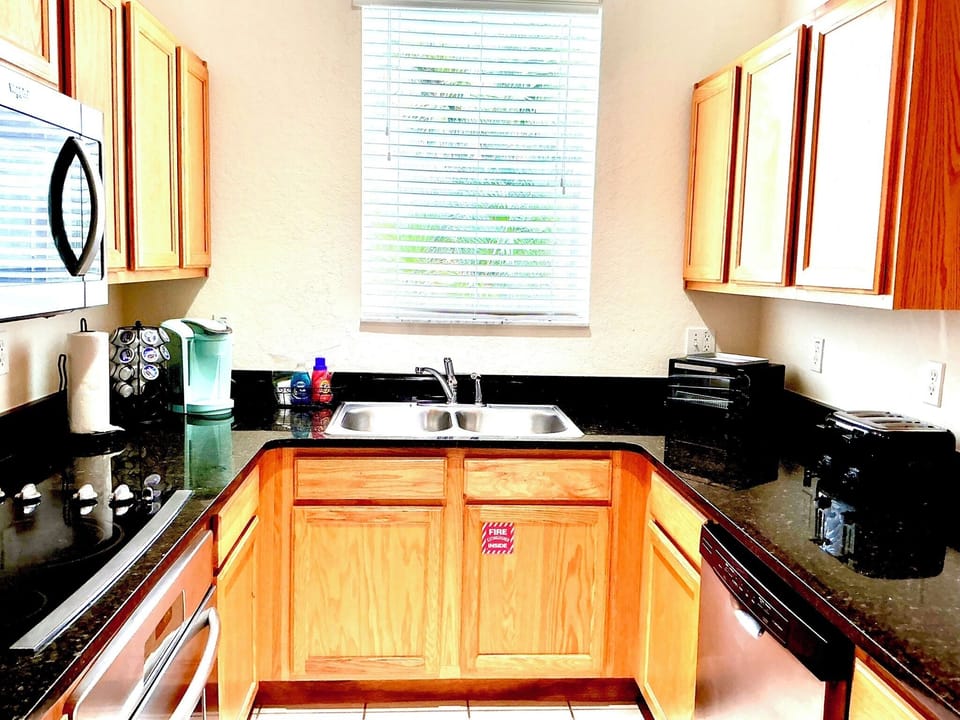 Well appointed kitchen with solid surface countertops and stainless appliances