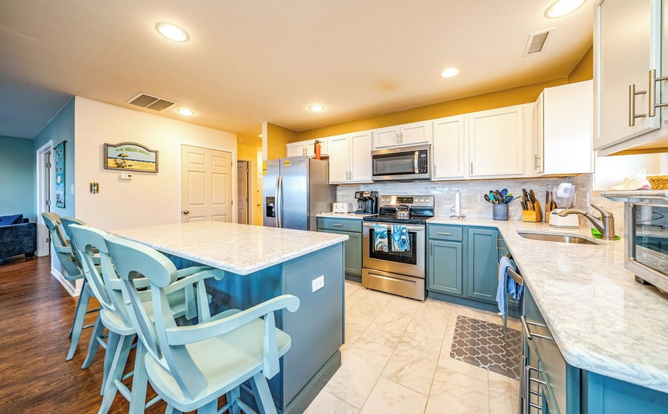 Cozy kitchen area with three chairs by the kitchen island
