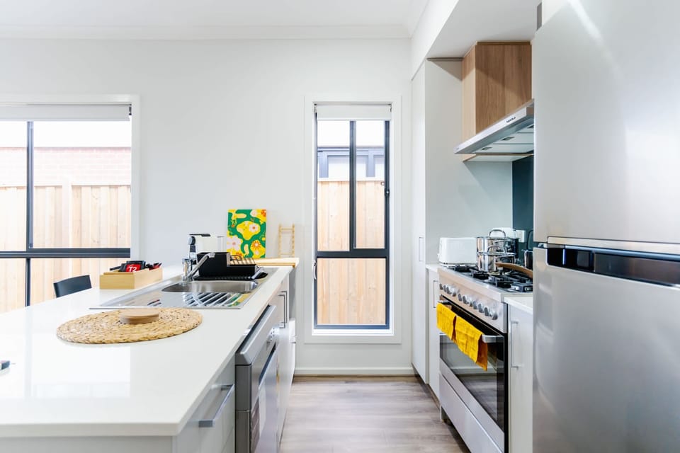 Well-equipped kitchen with stainless steel appliances, ample counter space, and a window providing natural light.