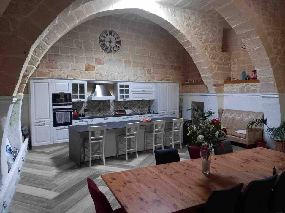 Large modern kitchen area with central island, open plan plus dining area overlooking the pool.