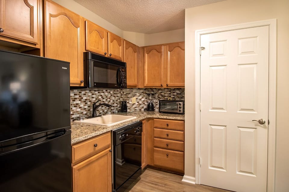Partial kitchen includes refrigerator, microwave, dishwasher, and toaster oven