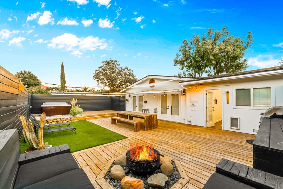 Entertain and unwind in a backyard oasis complete with firepit, BBQ, spa, dining area, and lounge seating.