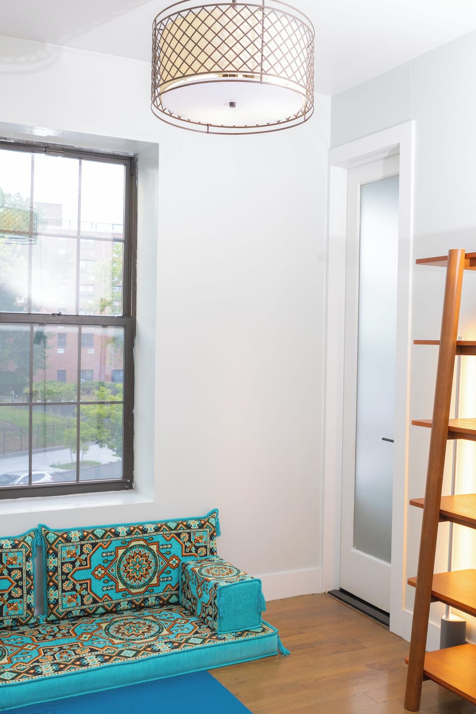 Yoga room featuring large yoga mat, small library of books, and floor sofa.