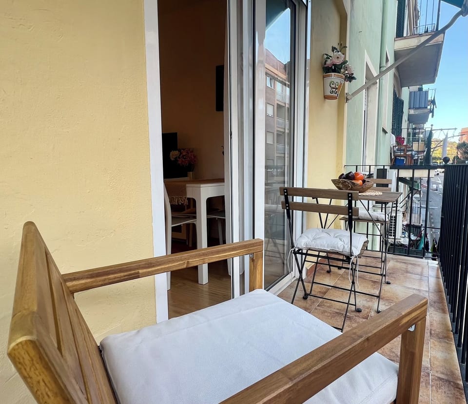 Cozy private balcony with bistro seating and sunny street views