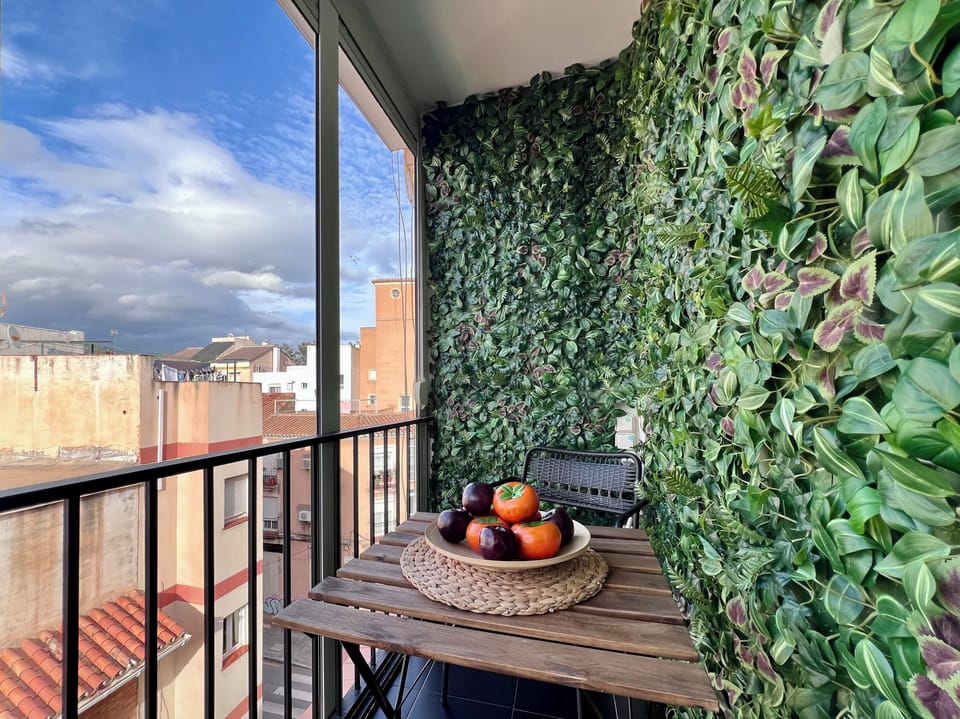 Cozy balcony with lush green wall and charming city views