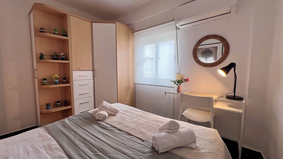 Bright bedroom with workspace, AC, and ample wardrobe storage