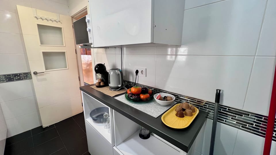Modern kitchen nook with coffee station, fruit, and sleek finishes