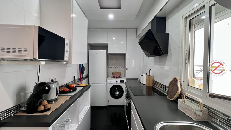Bright modern kitchen with sleek finishes and in-unit washer