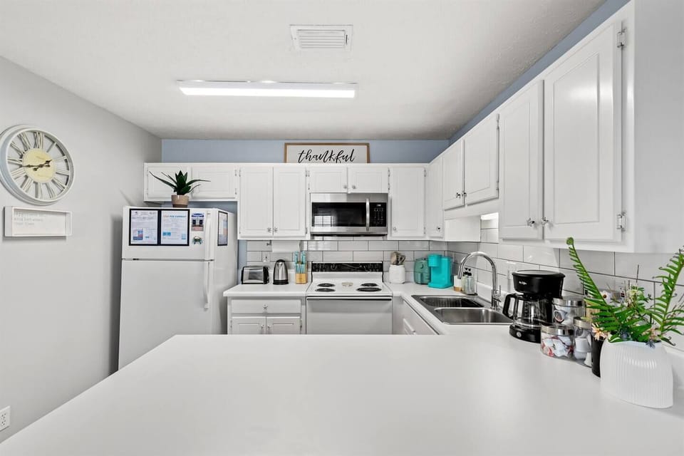 Cook with ease in the spacious, fully stocked kitchen! Featuring an air fryer, coffee bar with regular and decaf coffee, and sleek white modern decor.